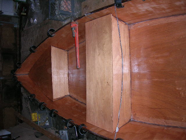 boat 12
Ist coat of epoxy on interior, rubrail (3 layers solid mahogany 1/4") installed.  Still have to fillet and glass seat top seams.
