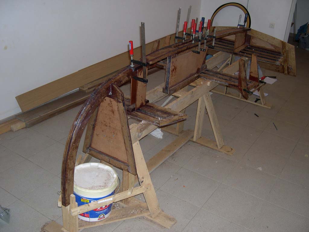 Frames on the Jig
I say it again here, this is NOT a boatplans-online boat. It is the building log of a Hartley TINA 9, a plywood on frames boat. The building method is totally different all designs in this site. Beware, there are no stich-and-glue pictures here. 

Here are the frames, bulkhead and transom, all fitted on the Jig. The stem and the keelson are also installed. Notice that the shape of the boat is defined by the centerboard box and the seats.
